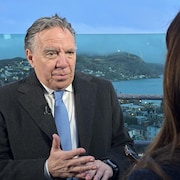 François Legault en entrevue, avec le paysage de Terre-Neuve-et-Labrador en arrière-plan.