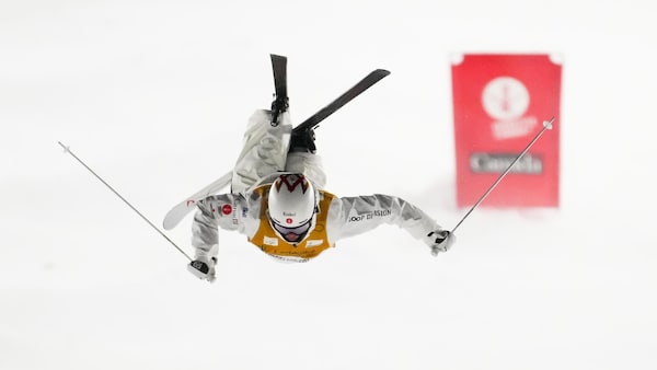 Il réalise un saut périlleux arrière sur la piste de ski.