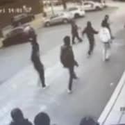 Des jeunes, filmés par une caméra de surveillance, entourent une policière.