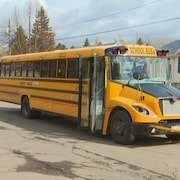 Un autobus scolaire à l'arrêt dans un quartier résidentiel.