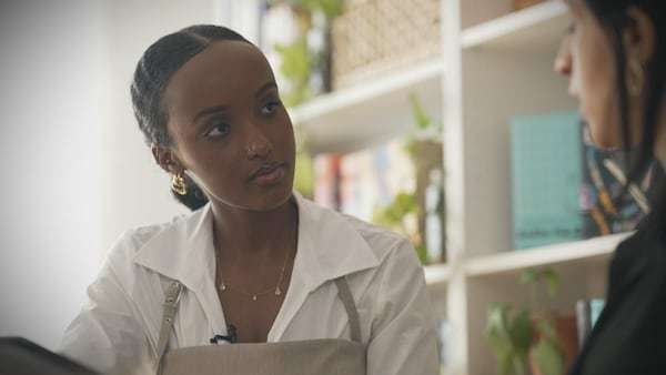 Deux femmes discutent dans un bureau.