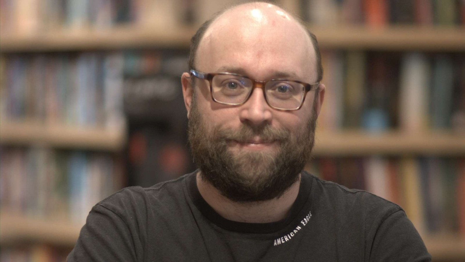 Félix Morin se tient debout derrière un bac rempli de livres.