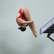 Simone Leathead dans les airs en position carpée lors d'un plongeon.