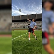 Un joueur lance le frisbee sur un terrain d'ultimate frisbee.