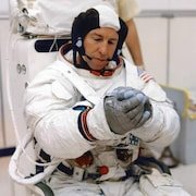 L'astronaute Jim Lovell portant sa combinaison.