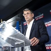 Le candidat conservateur Éric Duhaime devant un lutrin.