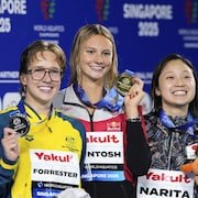 La médaillée d'or Summer McIntosh du Canada, au centre, entourée de la médaillée d'argent Jenna Forrester d'Australie, à gauche, et de la médaillée de bronze Mio Narita du Japon, pose sur le podium après la finale du 400 mètres quatre nages individuel féminin aux Championnats du monde de sports aquatiques à Singapour.