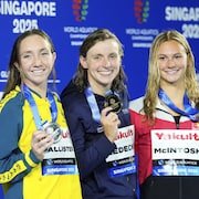 Trois nageuses médaillées au 800 m style libre au championnat du monde de sports aquatiques montrent leurs médailles.