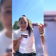 Ophélia montre une paire de bas composée d'une chaussette longue et d'une courte.