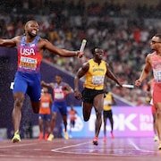 Noah Lyles célèbre en passant la ligne devant Andre De Grasse.