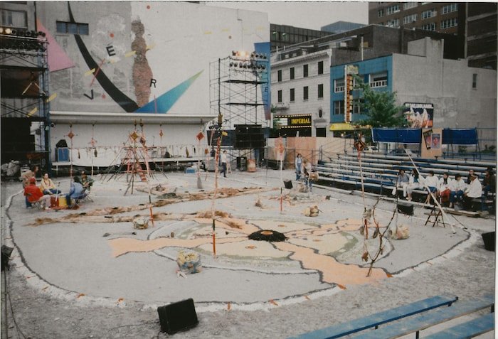 Des personnes sur une place préparent une pièce de théâtre.